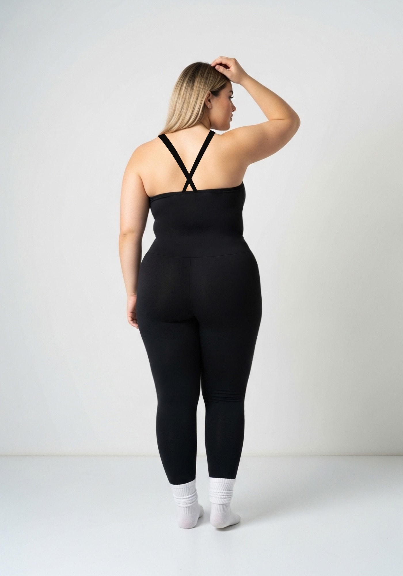 Enterizo negro Coqueta V-Mesh con escote en V y detalle de malla, tirantes cruzados y pierna larga.