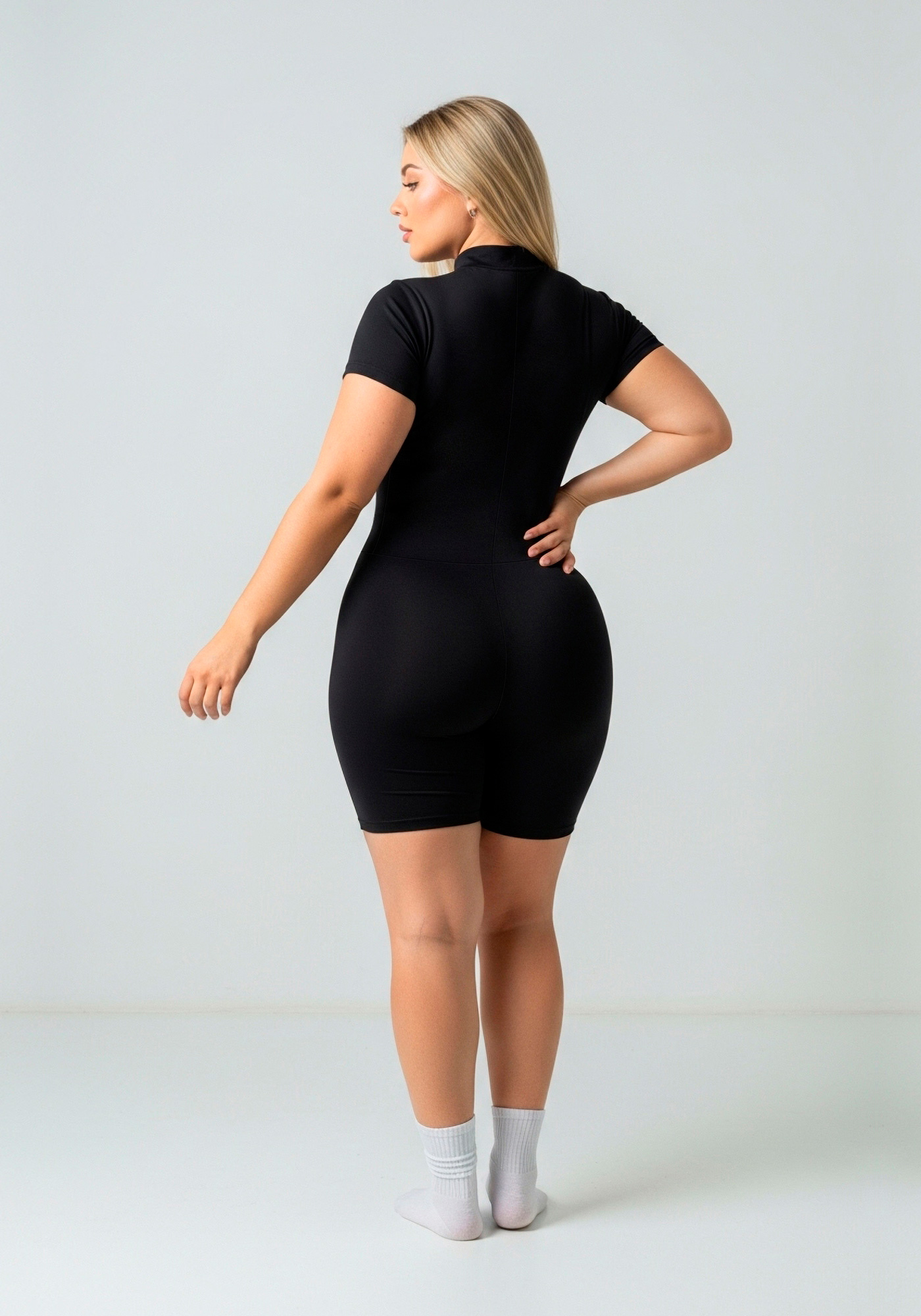 Enterizo negro Gomela ZipShort con manga corta, cierre frontal y pierna corta.