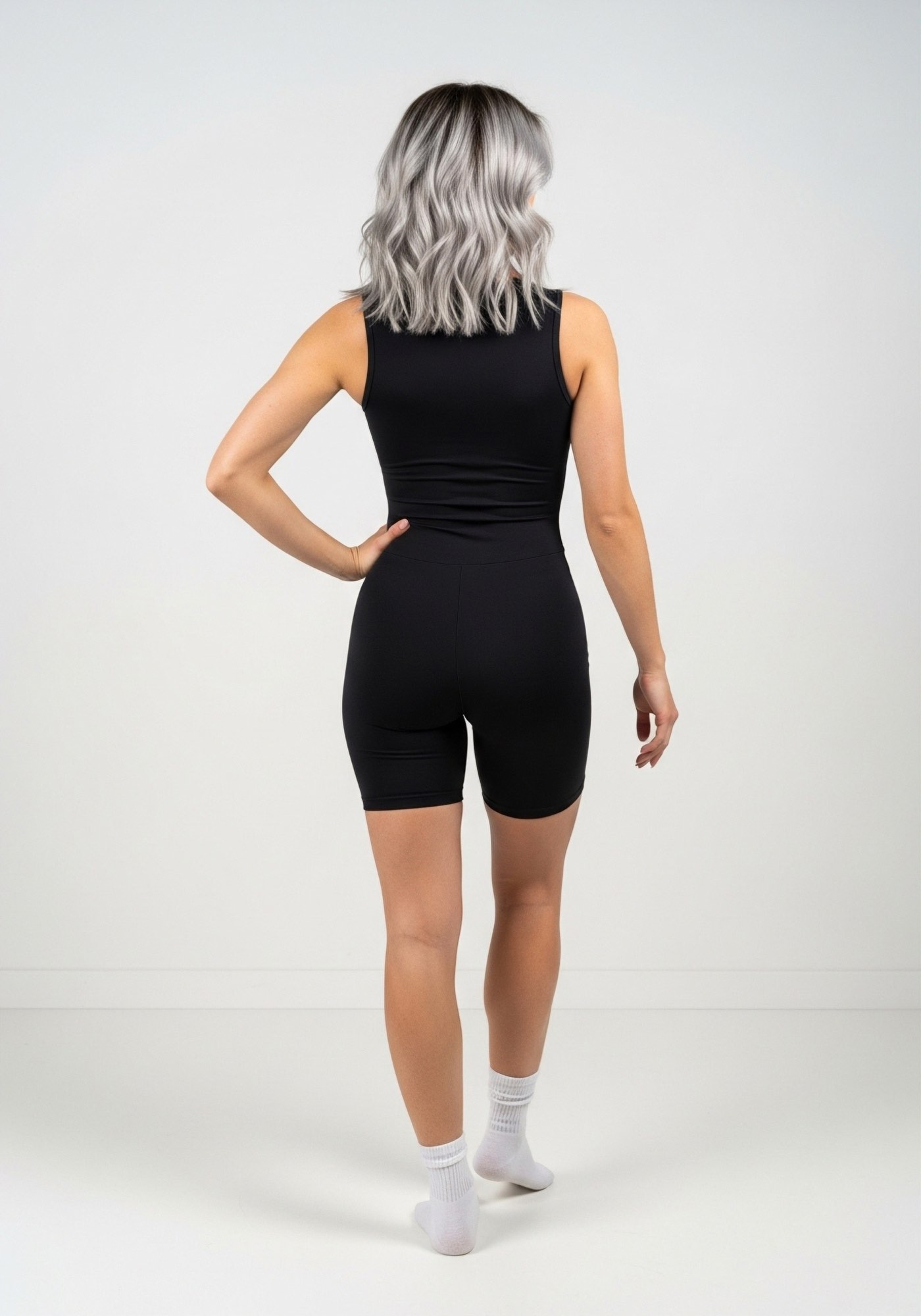 Gomela, enterizo negro con manga sisa, cierre frontal y pierna corta. Fresco, transpirable y cómodo para entrenar o uso diario.